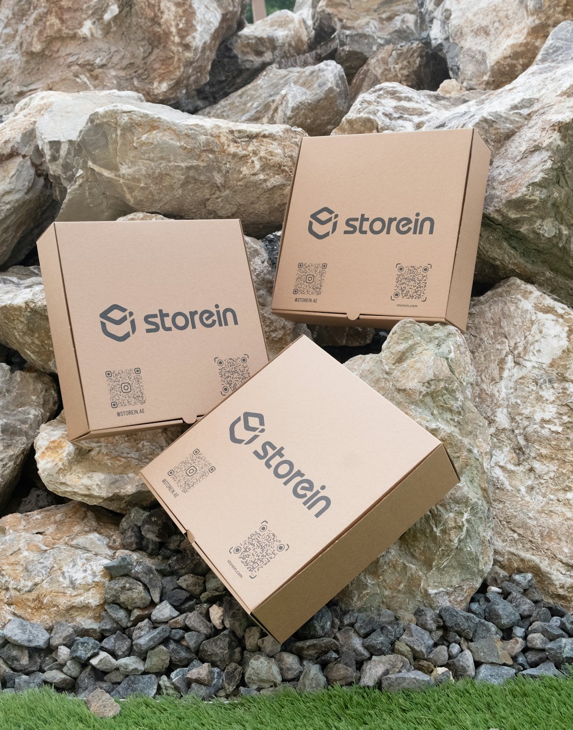 Three 'storein' branded boxes sit on rough rocks.